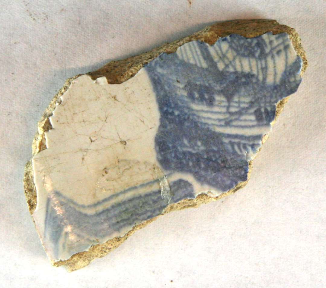 1 fragmentstump af blådekoreret flise med skibsmotiv. Største mål: 5,5 cm.