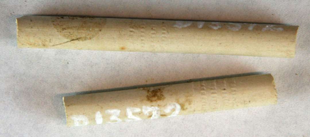 2 fragmentstumper af kridtpibestilke med svagt indpressede bælter i tandsnitmønster. Længde: 5 og 6,5 cm.