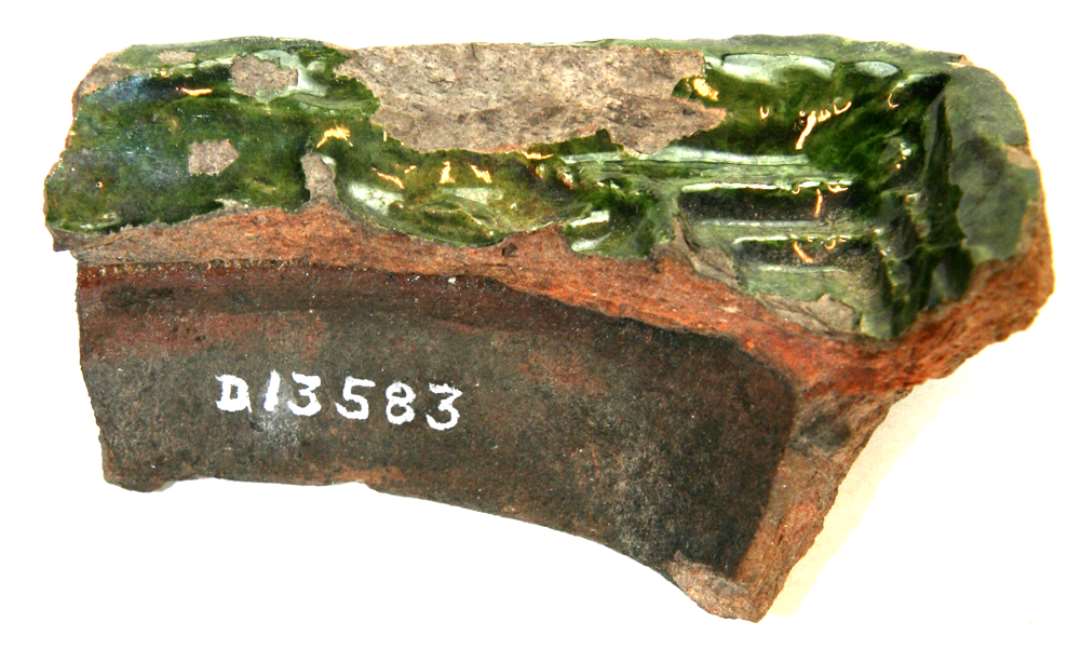 Hjørnefragment af grønglaseret kakkel med høj yderkant. Største mål: 10 cm.