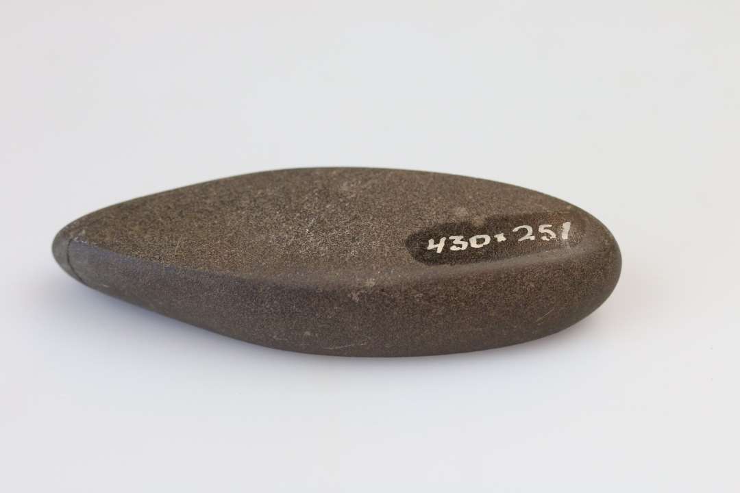 Banke/glittesten. Spidsoval form. Længde 8,0 cm. Finkornet sandsten der bærer spor af stærk brug. 