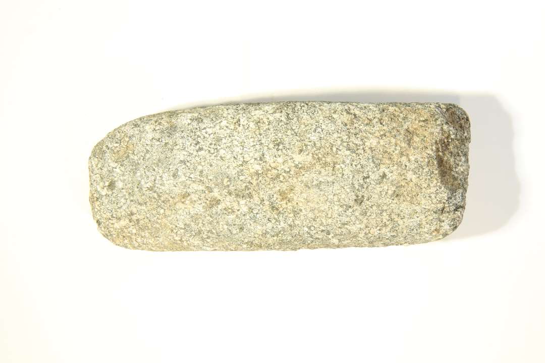 Økse af bjergart - finkornet granit - forvitret og beskadiget.  Længde    : 17.0 cm Bredde:     : 6,4 cm Tykkelse   : 4.5 cm ved nakkeende. 