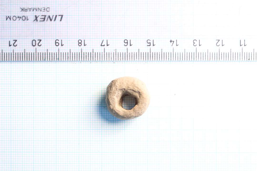 Tenvægt af bly. Assymmetrisk, klumpet udført. Diameter: 2 cm.