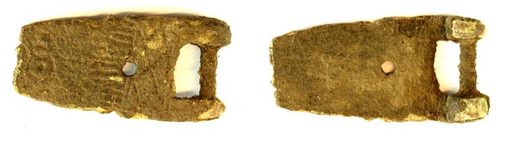 Fragment af bogspænde? af kobberlegering. Stregornamentik på oversiden. Mål: 22 x 11 mm. 

Bolt-Jørgensen 2019: Malle