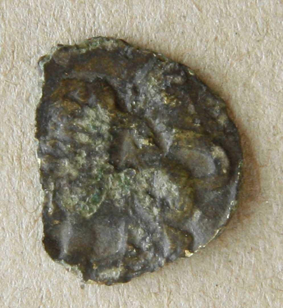 Plaket af bronzeblik. Formentlig påsyningssmykke fra 12-1300-tallet, af bronzeblik med rester af forgyldning og med et stående dyr (løve?) som motiv. Diameter: 21 mm.Diameter: 15 mm., se x7