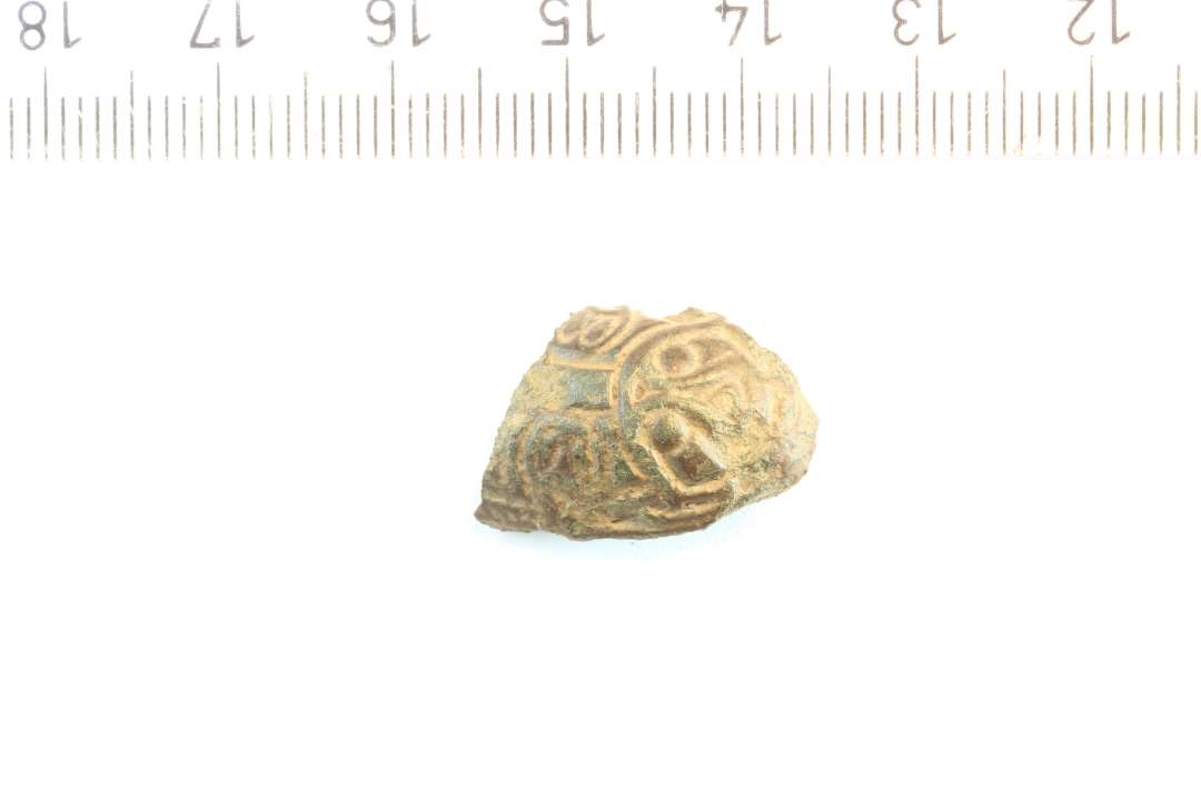 Fragment af lille, skålformet fibel med dyrehoved. største mål: 2 cm., bredde: 1,4 cm.