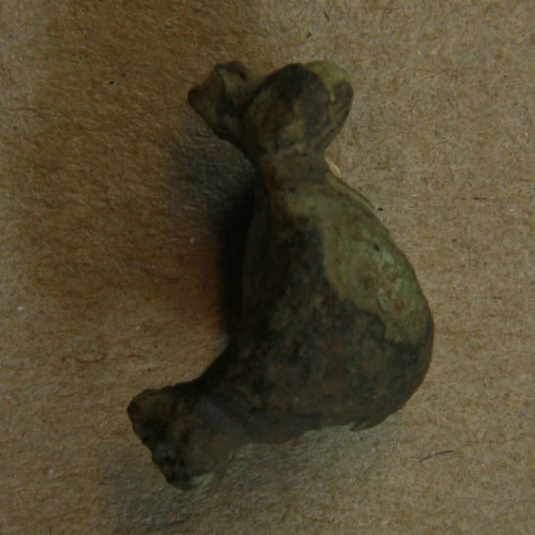 Fragment af kuglefibel i form af bøjle og lille støbt bronzekugle samt rest af den gennemgående jerntråd. Største mål: 20 mm