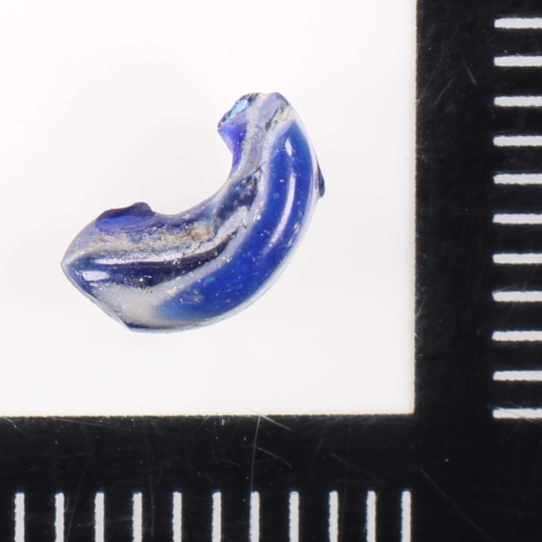 Glasset er nærmest lagdelt blåt/hvidt og der er således ikke tale om pålagte hvide tråde på en blå perle.  Usædvanlig perle!