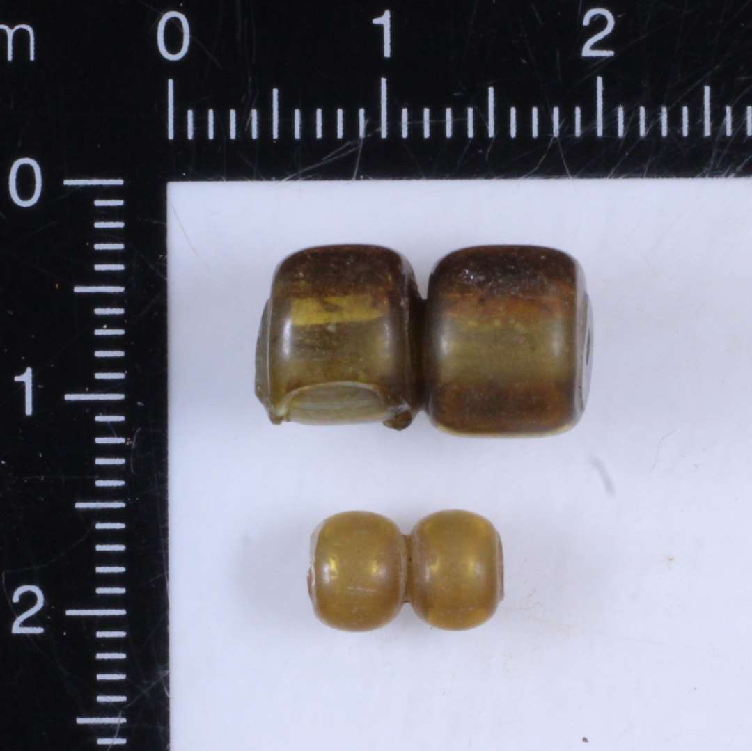 Halv perle, 2 led. Hel meget stor perle, to led, yderste lag afskallet på det ene led. Begge med gennemfående hul.
