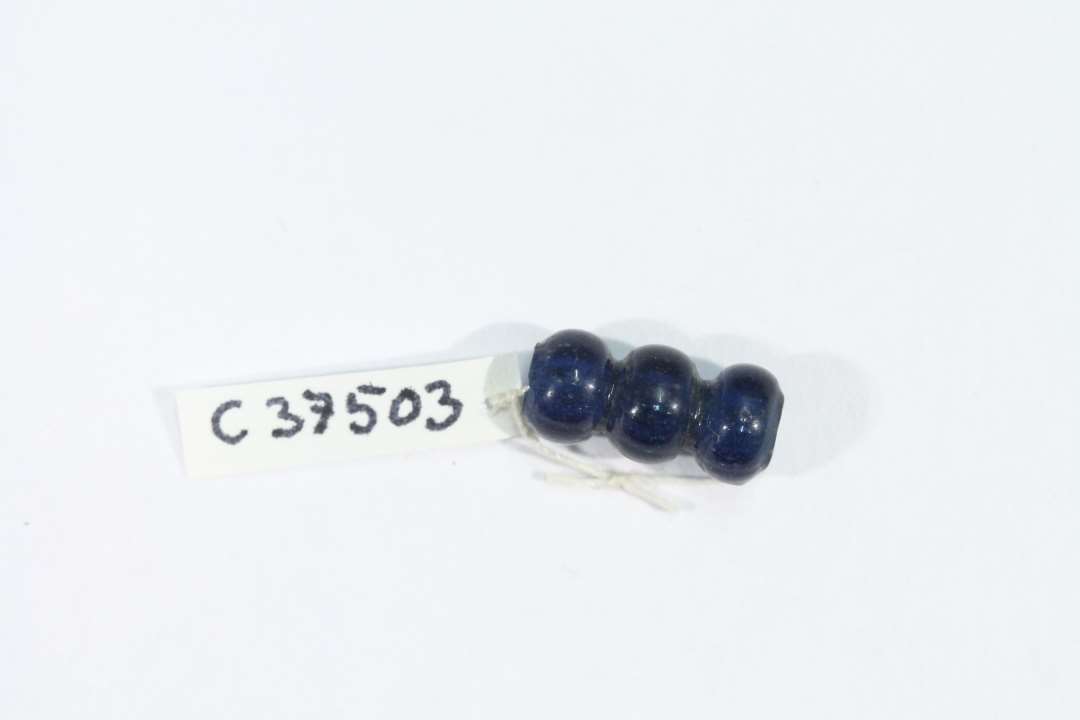 Blå glasperle. Segmenteret. 3 led. Længde: 1,3 cm., diameter: 0,5 cm.