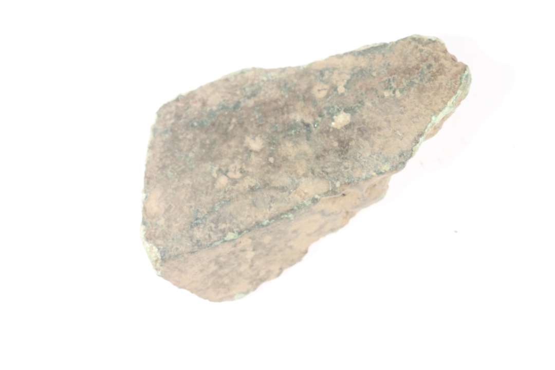 Stump af bronze, måske fragment af ben fra malmgryde? Mål: 4x2,5x1 cm.