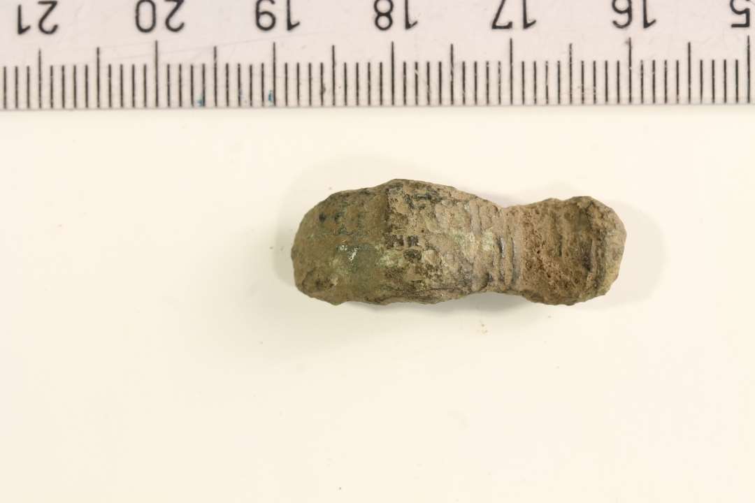 Fragment af kort ligearmet fibel. Længde: 2,8 cm.