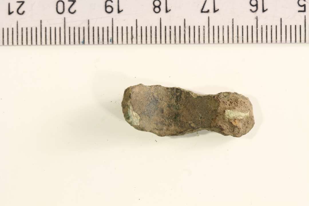 Fragment af kort ligearmet fibel. Længde: 2,8 cm.