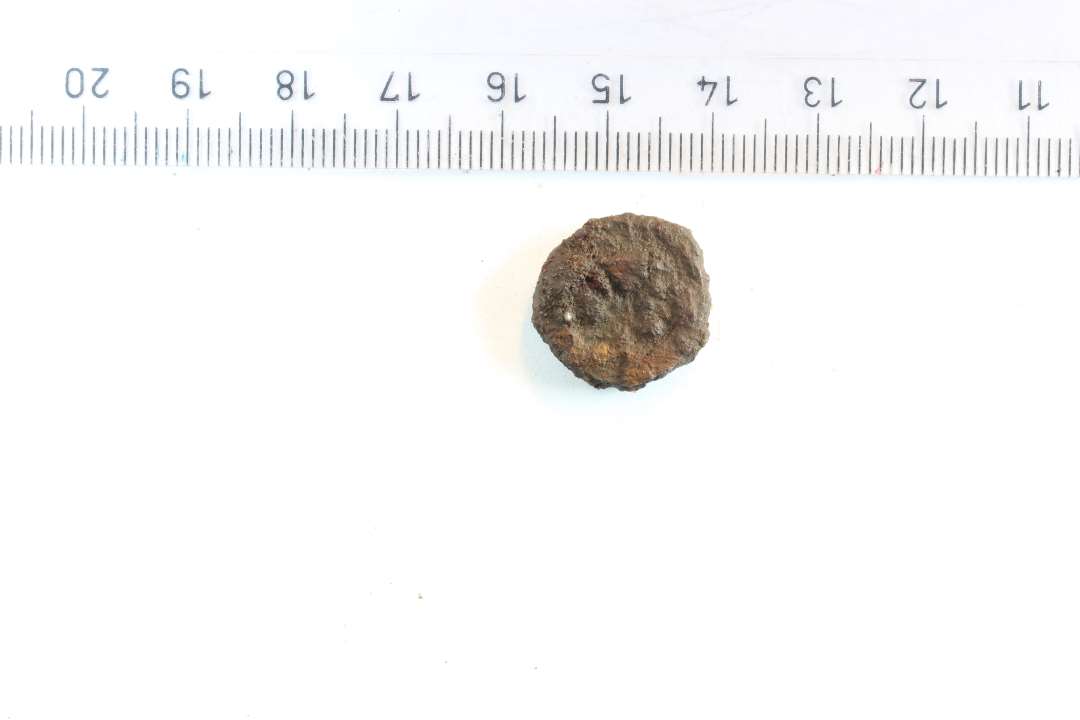 Mønt. ret tyk, ser jernholdig/rusten ud. Med præg... diameter: 1,6 cm. Datering?