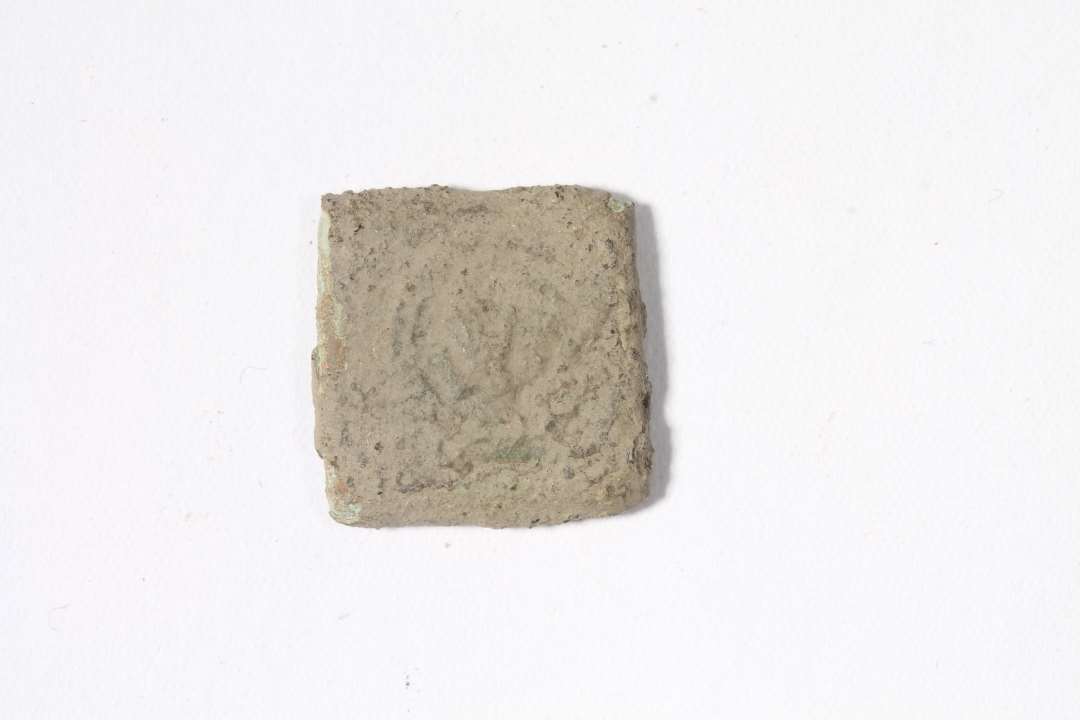 Mønt vægtlod.Flad, kvadratisk, med svage rester af præg. Mål: 1,5x1,5 cm. Møntvægtloddet er belgisk. Motivet viser en (utydelig) hånd, som har været anvendt af forskellige fabrikanter i Antwerpen i det 16. århundrede