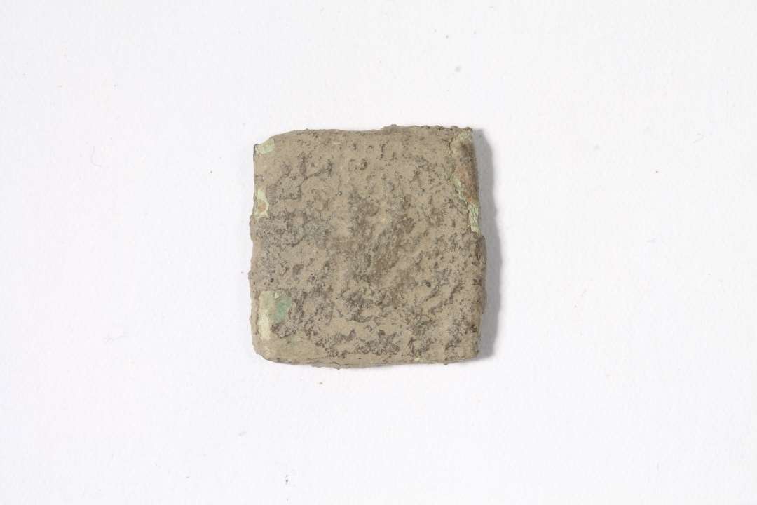 Mønt vægtlod.Flad, kvadratisk, med svage rester af præg. Mål: 1,5x1,5 cm. Møntvægtloddet er belgisk. Motivet viser en (utydelig) hånd, som har været anvendt af forskellige fabrikanter i Antwerpen i det 16. århundrede