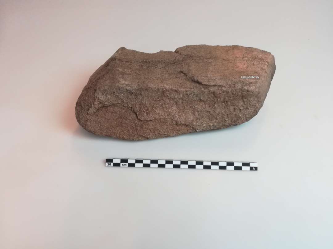Sten på ca. 30 x 20 cm, med tydelige dybe slibespor. 