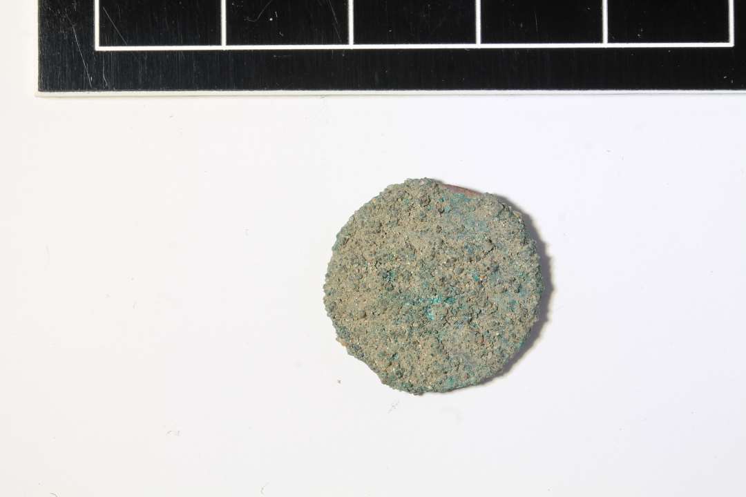 Mønt, hvor der på den delvis synlige forside vistnok anes et kronet F, ø 17 mm. Formentlig 1 Schilling Courant, Mecklenburg Schwerin, slut 1700-tal